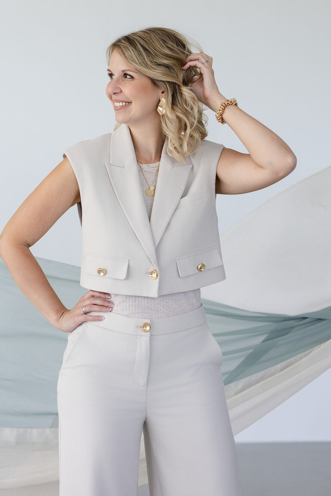 Iris Gassner im eleganten Look vor fließendem Stoff in Salbeigrün und Bordeaux